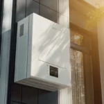 Solar inverter mounted on a wall, connected to rooftop solar panels, with energy data on display.